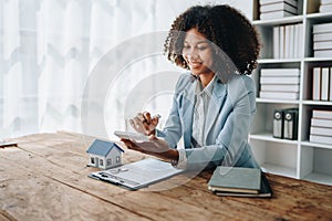 Real estate agent, African American businesswoman Africans use smartphone and calculators to offer mortgages to their