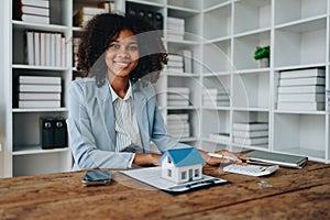 Real estate agent, African American businesswoman Africans use smartphone and calculators to offer mortgages to their