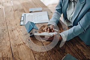 Real estate agent, African American businesswoman Africans use smartphone and calculators to offer mortgages to their