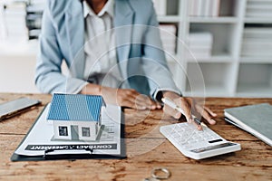 Real estate agent, African American businesswoman Africans use smartphone and calculators to offer mortgages to their