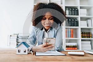 Real estate agent, African American businesswoman Africans use smartphone and calculators to offer mortgages to their