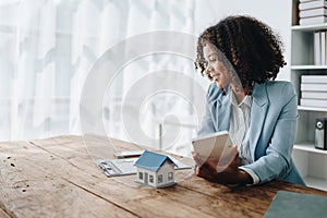 Real estate agent, African American businesswoman Africans use smartphone and calculators to offer mortgages to their