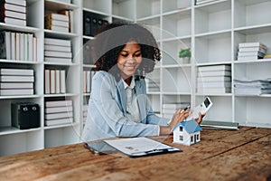 Real estate agent, African American businesswoman Africans use smartphone and calculators to offer mortgages to their