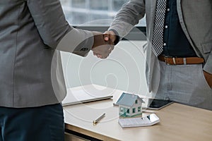 Real estate agent African American handshake to customer indian to congratulate after signing a contract to buy a house