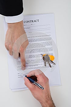 Real Estate Agent Assisting Client To Sign Contract Paper