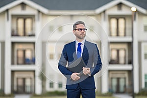 Real estate agent business man in suit hold holder clipboards outside. Hispanic Businessman. Business Man broker or real photo