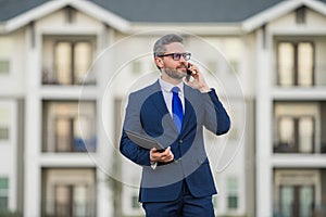 Real estate agent business man in suit hold holder clipboards and talking on phone. Businessman. Business Man broker or