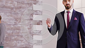 Real estate agent in business suit smiling and showing apartment key