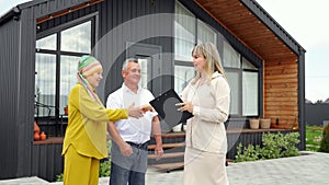 Real estate agent congratulates married couple with house