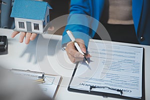 Real estate agent and customer signing contract to buy house, insurance or loan real estate.rent a house,get insurance or loan