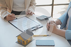 Real estate agent and customer signing contract to buy house, insurance or loan real estate.rent a house,get insurance or loan