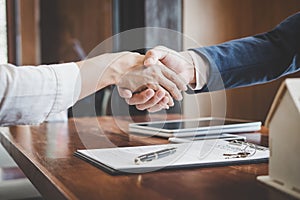 Real estate agent and customers shaking hands together celebrating finished contract after about home insurance and investment lo