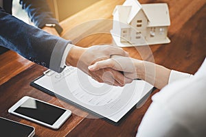 Real estate agent and customers shaking hands together celebrating finished contract after about home insurance and investment lo