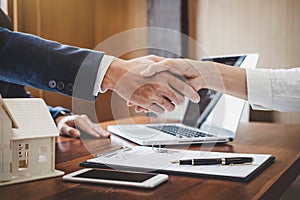 Real estate agent and customers shaking hands together celebrating finished contract after about home insurance and investment lo