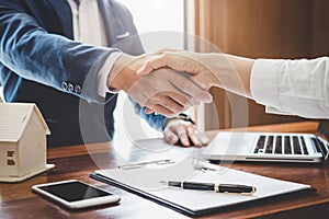 Real estate agent and customers shaking hands together celebrating finished contract after about home insurance and investment lo