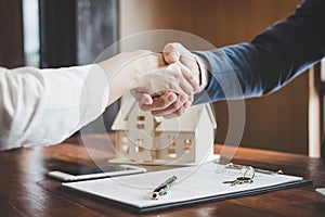 Real estate agent and customers shaking hands together celebrating finished contract after about home insurance and investment lo