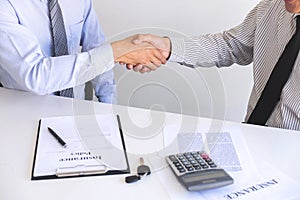 Real estate agent and customers shaking hands together celebrating finished contract after about home insurance and investment