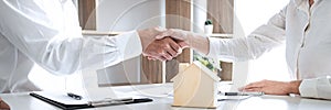 Real estate agent and customers shaking hands together celebrating finished contract after signing about home insurance and