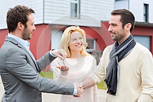 Real estate agent delivers keys to young atractive couple