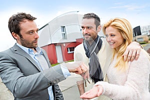 Real estate agent delivers keys to young atractive couple