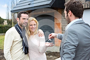 Real estate agent delivers keys to young atractive couple