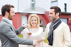 Real estate agent delivers keys to young atractive couple