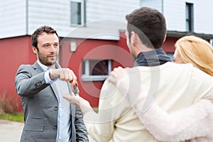 Real estate agent delivers keys to young atractive couple