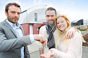 Real estate agent delivers keys to young atractive couple