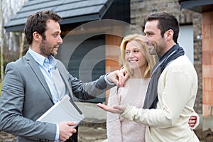 Real estate agent delivers keys to young atractive couple