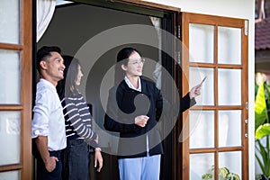 Real estate agent giving buy or tenant tour about big new house. Couple or husband and wife who plan property investment