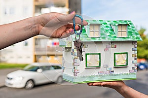 Real estate agent giving house keys to a new property owner, who