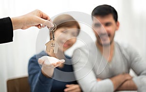 Real Estate Agent giving key of new house to Young couple.