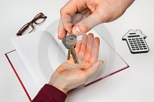 Real estate agent giving keys from new house to young woman