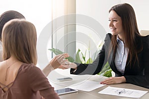 Real estate agent giving keys to own apartment to couple