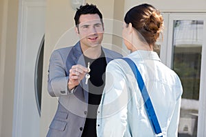real estate agent giving keys to woman