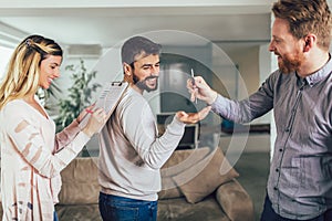 Real estate agent giving keys to young couple