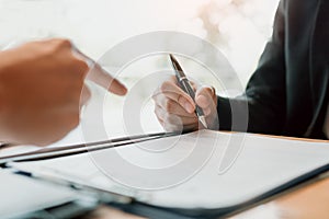 Real estate agent hand showing customer where to writing sign a contract of house or mortgage papers