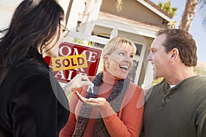 Real Estate Agent Handing Keys to Excited Couple