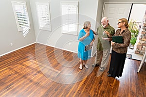 Real Estate Agent Handing New House Keys to Senior Couple