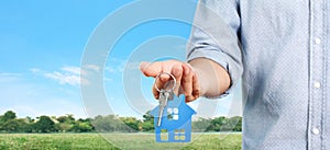 Real estate agent handing over house keys in  hand