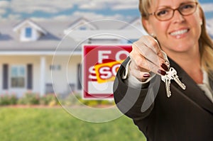 Real Estate Agent Handing Over New House Keys with Sold Sign Behind