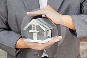 Real estate agent hands holding the home model or Sales presenting home insurance