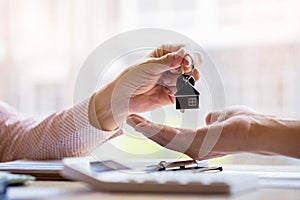 Real estate agent holding filing keys to customer after signing rental lease contract of sale purchase agreement