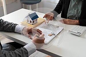 Real estate agent holding house key to his client after signing contract,concept for real estate, moving home or renting
