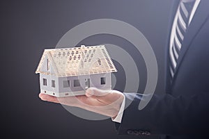 Real estate agent holding house model