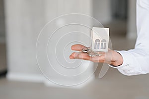 Real estate agent holding key and house model