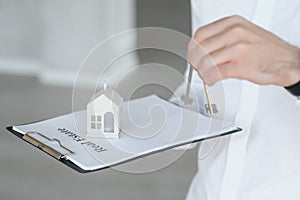 Real estate agent holding key and house model