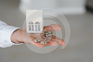 Real estate agent holding key and house model