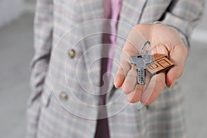Real estate agent holding key indoors, closeup