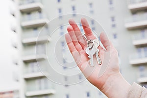 A real estate agent holding keys to a new apartment in her hands.